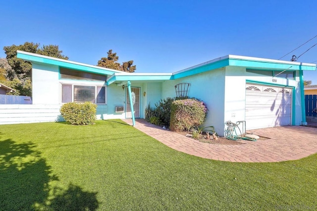 single story home featuring a garage and a front yard