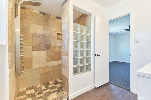 bathroom with ceiling fan, tiled shower, and hardwood / wood-style flooring