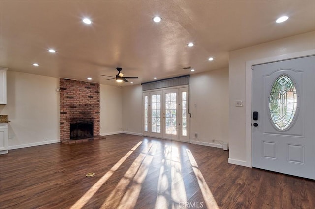 foyer with ceiling fan, a fireplace, and dark hardwood / wood-style flooring