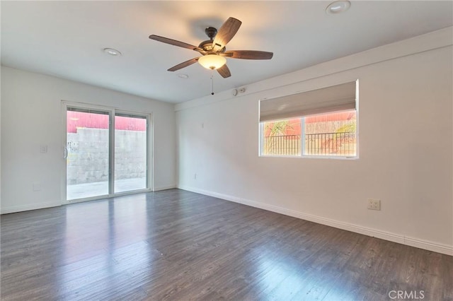 spare room with dark wood-type flooring, ceiling fan, and plenty of natural light