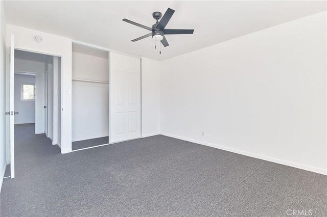 unfurnished bedroom with dark carpet, a closet, and ceiling fan