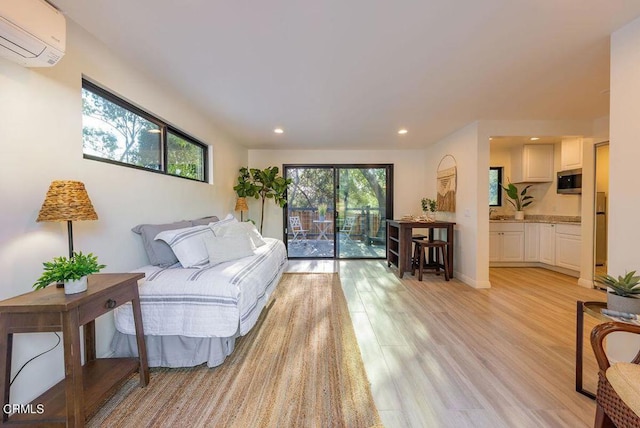 living room with a wall mounted AC and light wood-type flooring