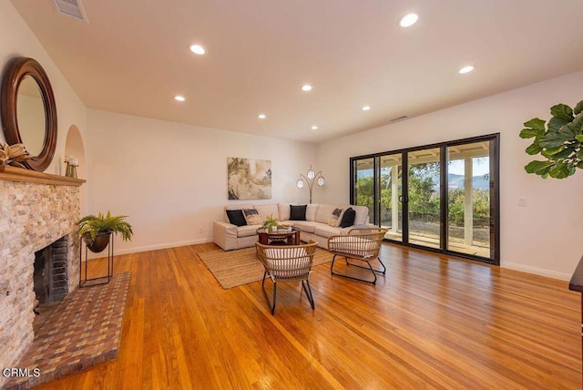 living room featuring hardwood / wood-style flooring and a brick fireplace