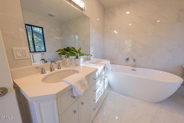 bathroom featuring vanity, a bath, and tile walls