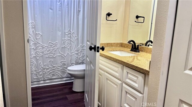 bathroom with hardwood / wood-style flooring, vanity, and toilet