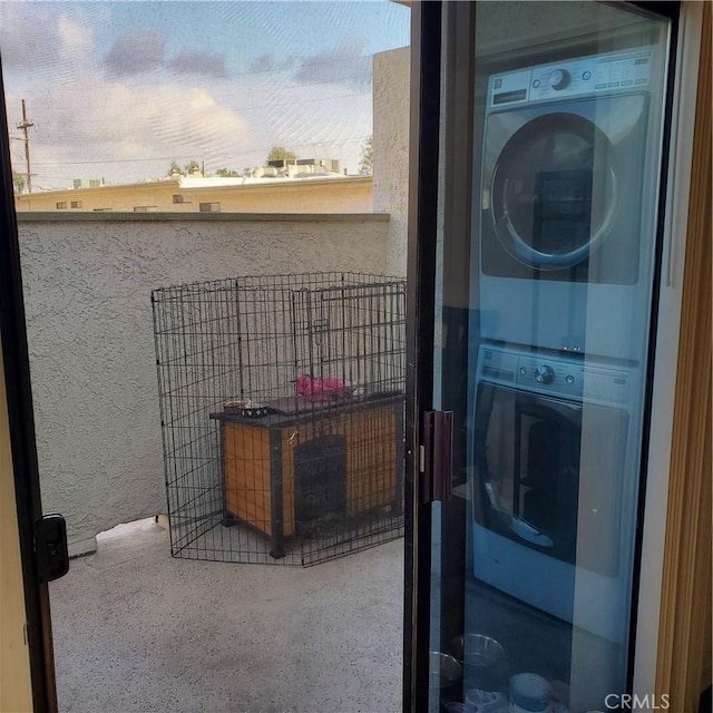 washroom featuring stacked washer and clothes dryer