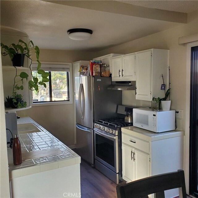 kitchen with white cabinetry, tile countertops, light wood-type flooring, and stainless steel gas stove