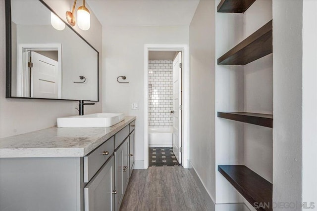 bathroom with hardwood / wood-style flooring, vanity, and shower / bath combination