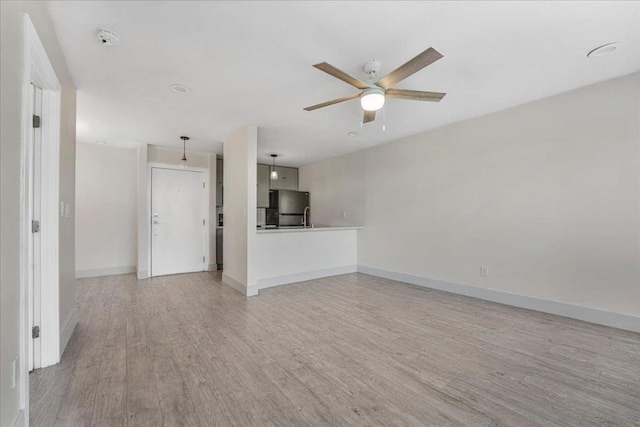 unfurnished living room with light hardwood / wood-style flooring and ceiling fan