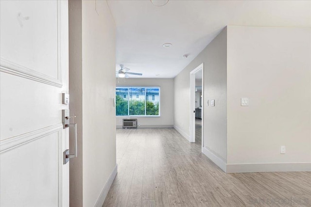 corridor with a wall mounted air conditioner and light wood-type flooring