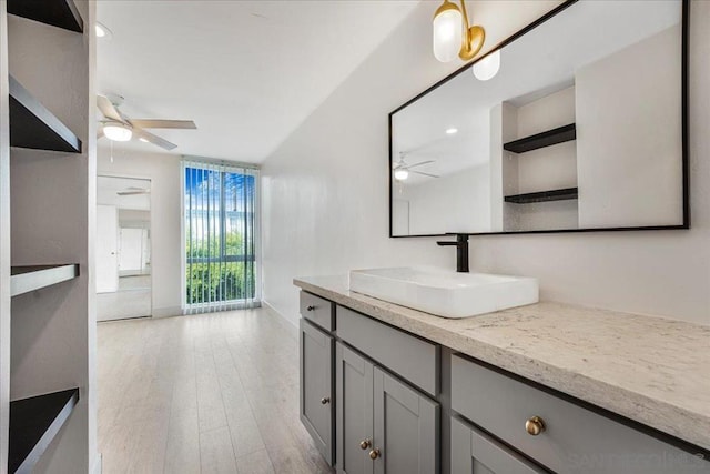 bathroom with hardwood / wood-style flooring, ceiling fan, and vanity