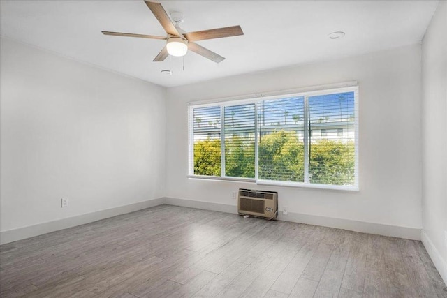 unfurnished room with hardwood / wood-style floors, a wall mounted air conditioner, and ceiling fan