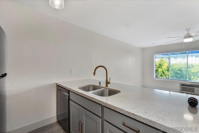 kitchen with sink, gray cabinets, a wall mounted AC, light stone counters, and stainless steel dishwasher