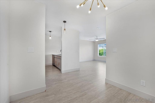 corridor featuring a notable chandelier, light hardwood / wood-style floors, and sink