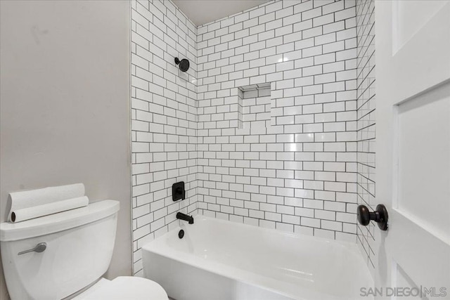 bathroom featuring toilet and tiled shower / bath