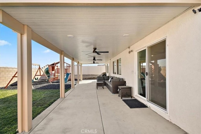 view of patio / terrace with a fenced backyard, ceiling fan, a playground, and an outdoor living space