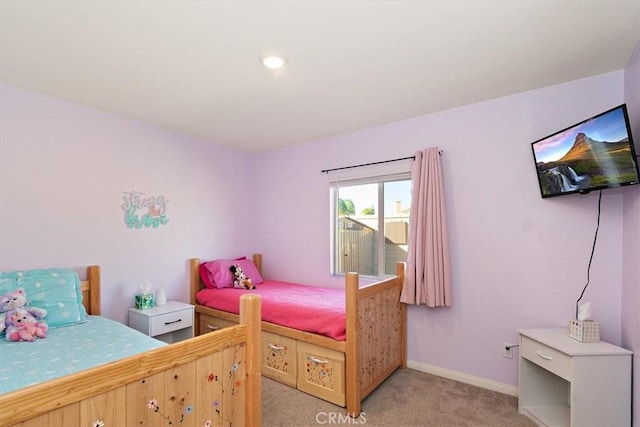 bedroom featuring light carpet and baseboards