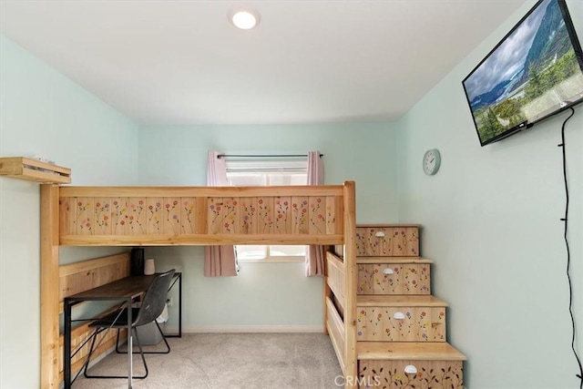 bedroom with baseboards and light colored carpet