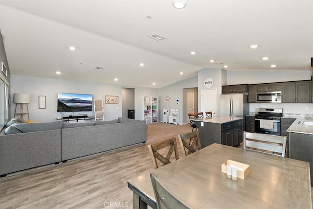 dining space with vaulted ceiling, visible vents, light wood-style flooring, and recessed lighting