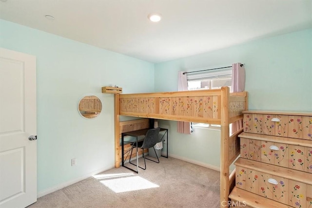 bedroom with baseboards and light colored carpet