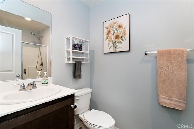 bathroom with toilet, a stall shower, and vanity