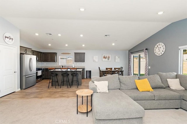 living area featuring lofted ceiling and recessed lighting