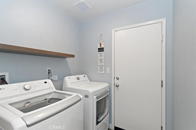 washroom with laundry area, washing machine and dryer, and visible vents