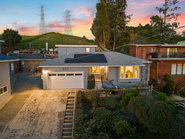 view of front of property with a garage and solar panels