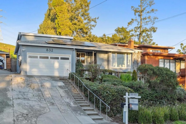 view of front of property featuring a garage and solar panels