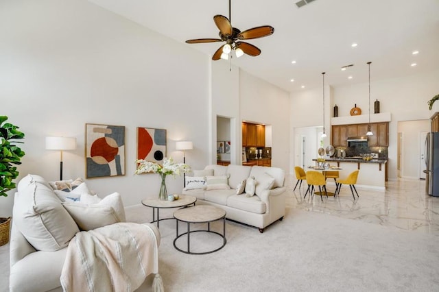 living room featuring ceiling fan and a high ceiling