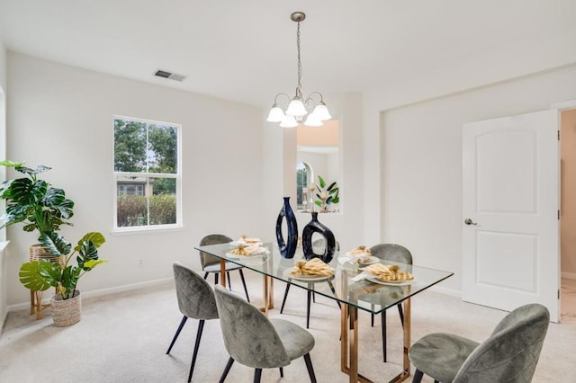 carpeted dining room featuring a chandelier