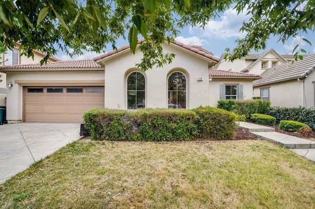 mediterranean / spanish-style house with a garage and a front yard