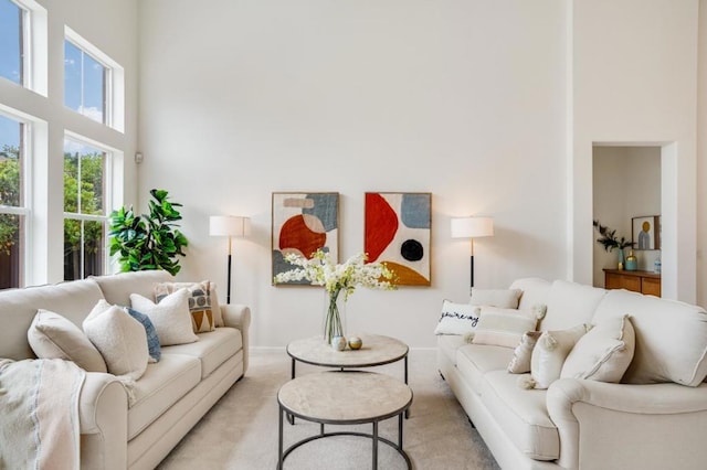 carpeted living room featuring a high ceiling