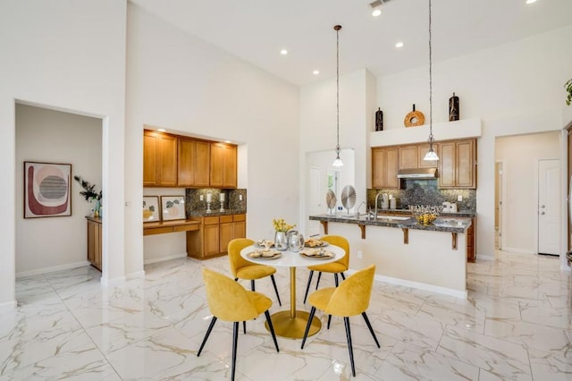 dining space featuring sink and a high ceiling