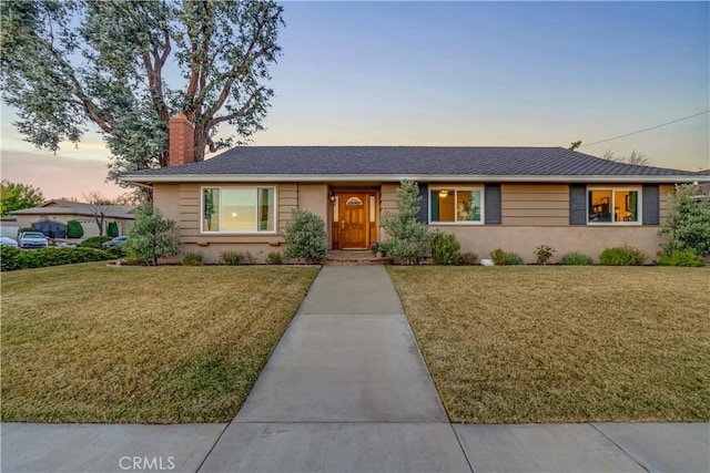 ranch-style home featuring a yard