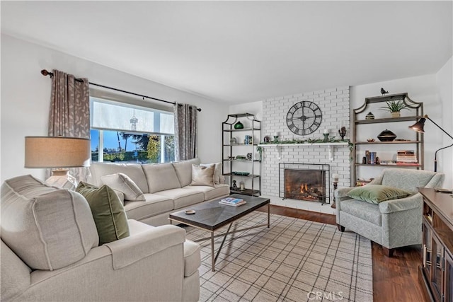 living room featuring wood-type flooring and a brick fireplace