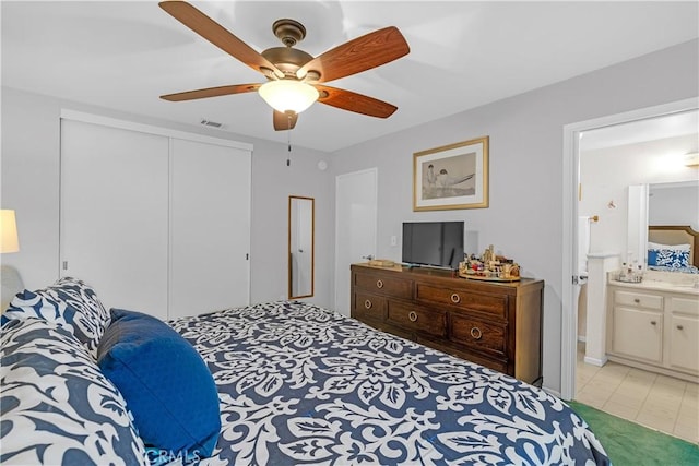 bedroom with connected bathroom, ceiling fan, and a closet