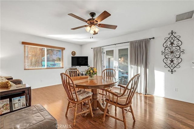 dining space featuring wood-type flooring, ceiling fan, and french doors