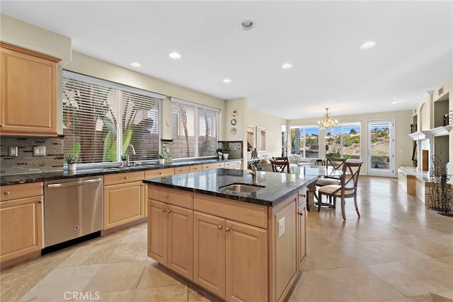 kitchen featuring sink, light brown cabinets, stainless steel dishwasher, plenty of natural light, and a kitchen island with sink