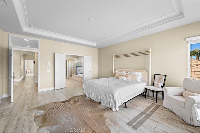 bedroom with ornamental molding, a raised ceiling, and light hardwood / wood-style flooring