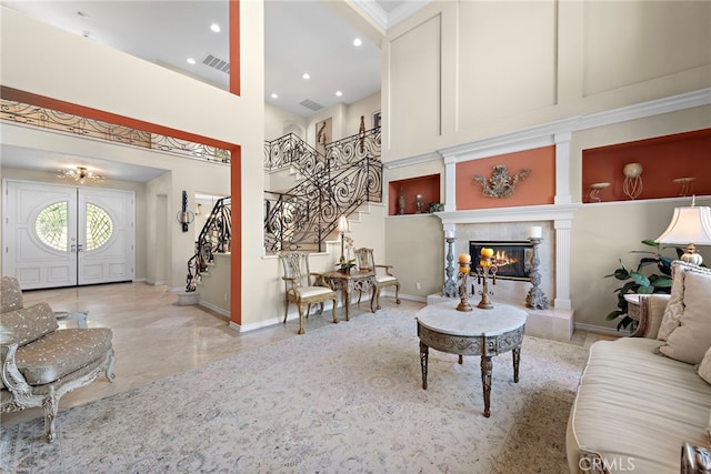 living room with a towering ceiling and a high end fireplace