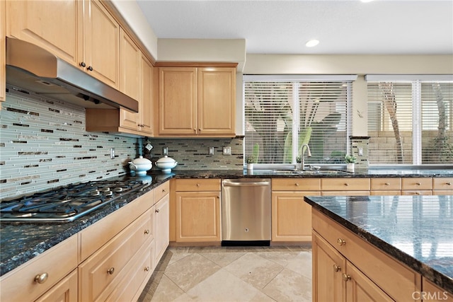 kitchen featuring decorative backsplash, light brown cabinets, dark stone counters, and appliances with stainless steel finishes