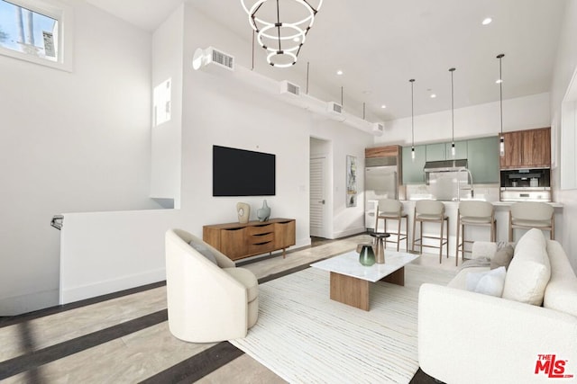 living room featuring a towering ceiling and a chandelier