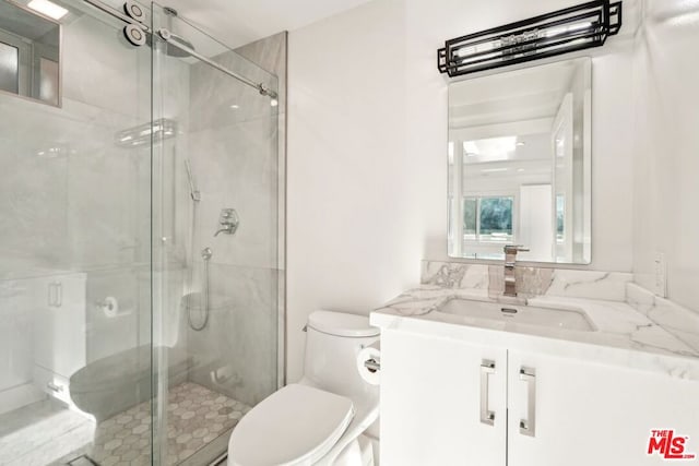 bathroom with walk in shower, vanity, and toilet