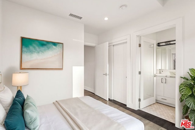 bedroom featuring dark hardwood / wood-style floors and connected bathroom