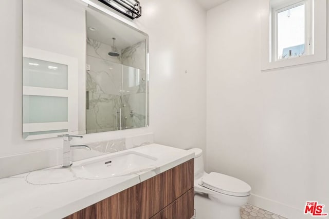 bathroom featuring vanity, a shower with door, and toilet