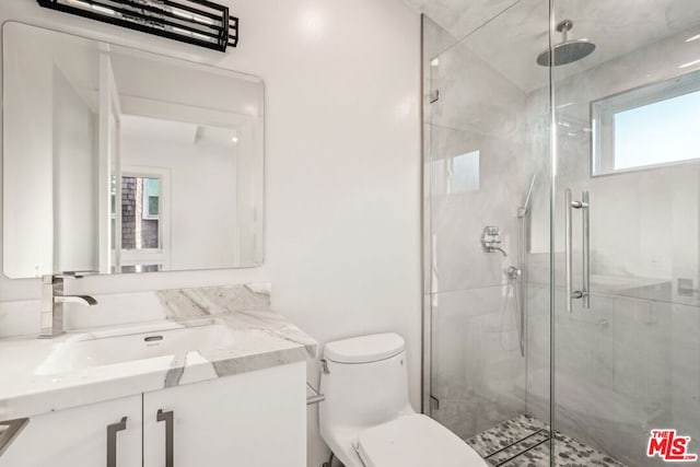 bathroom with walk in shower, vanity, and toilet