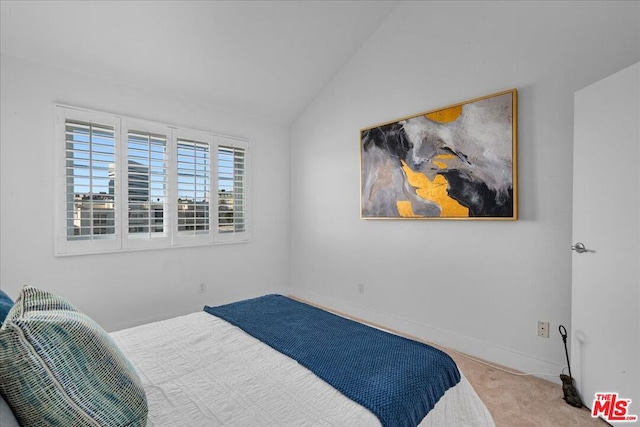 bedroom with lofted ceiling and light colored carpet