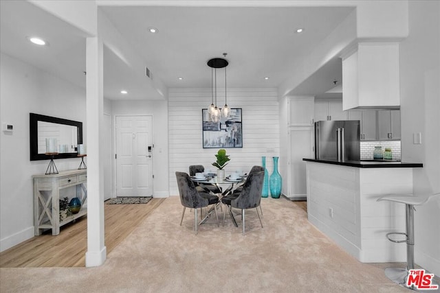 dining space featuring light colored carpet and a chandelier