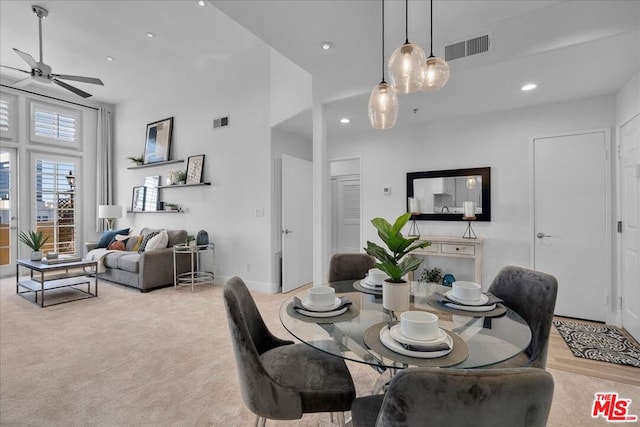 dining area featuring light carpet and ceiling fan